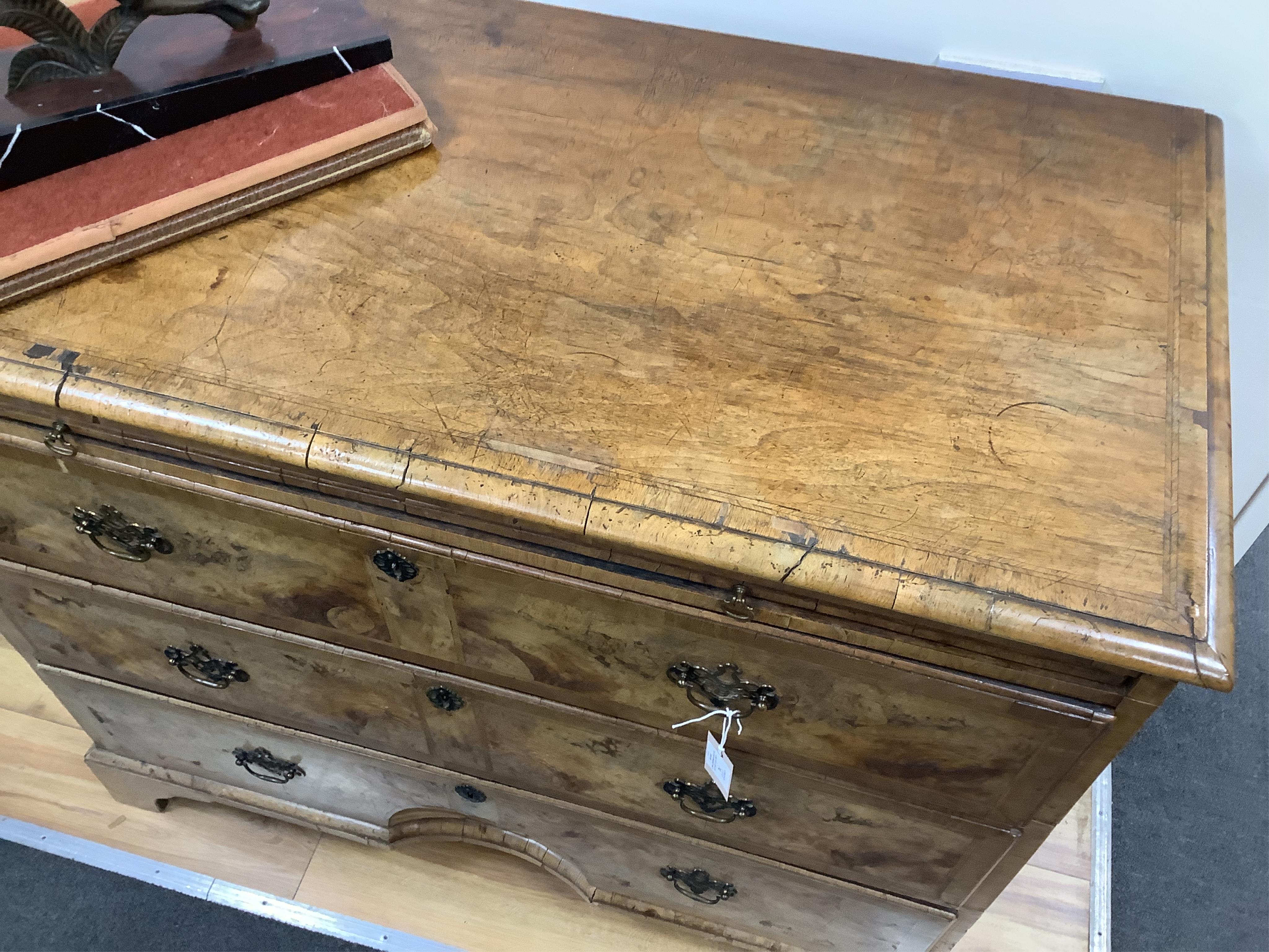 A mid 18th century feather banded walnut concave starburst walnut chest of three drawers, with brushing slide, width 108cm, depth 54cm, height 92cm
